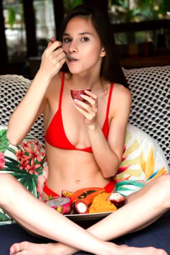 naked young lady playing and eating ripe